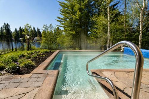 a swimming pool with a hand rail in a yard at Tremblant Prestige - BONDURANT 95-10 in Mont-Tremblant