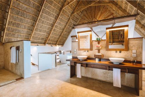 a bathroom with two sinks in a room at Zanzibar Sunrise at Bandas in Matemwe