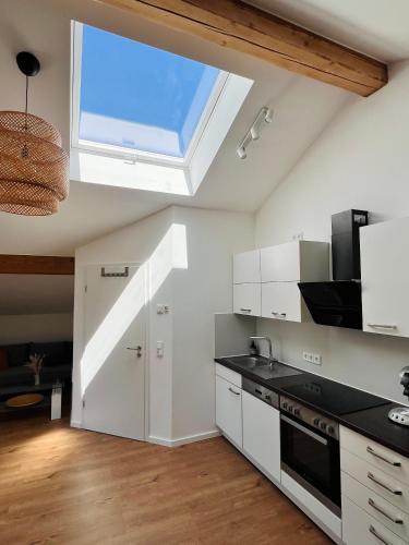 a kitchen with white cabinets and a skylight at Apartment am Starnberger See in Tutzing