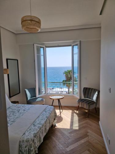 a bedroom with a bed and a view of the ocean at Azur Pearl - Luxury Sea View Apartement - La plage à vos pieds in Nice