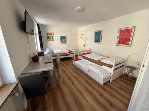 a room with two bunk beds and a desk at Haus zur Eiche Private 1 Zimmerstudios in Chur