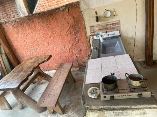 an outdoor kitchen with a stove and a picnic table at Camping & Glamping For All in Itaúnas