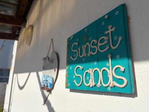 a sign on a building that reads sweet songs at Sunset Sands in St. Helena Bay