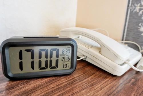 an alarm clock sitting on a table next to a phone at Best Western Hotel Causeway Bay in Hong Kong