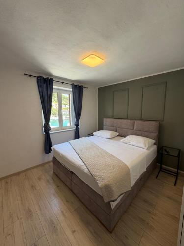 a bedroom with a large bed and a window at Apartmani Brač in Pučišća