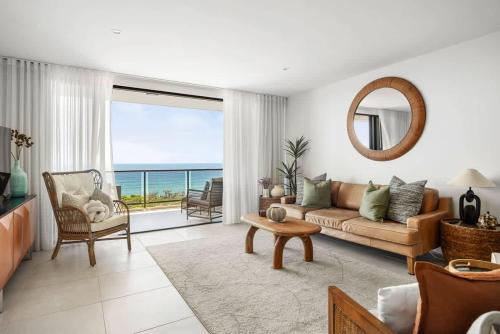 a living room with a couch and a view of the ocean at Postcard on Sunrise in Sunrise Beach