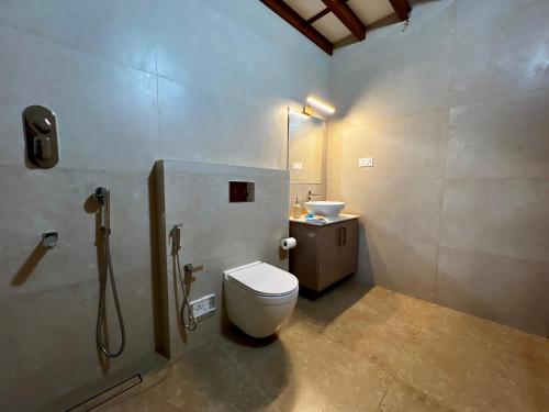 a bathroom with a toilet and a sink at Haritham Heritage Villa in Vadakkāncheri