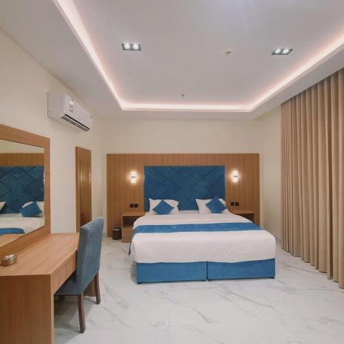 a hotel room with a large bed and a desk at الديار الفاخرة للشقق المخدومة - جيزان in Jazan