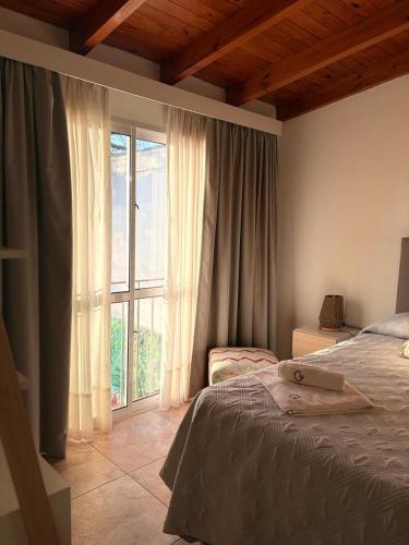 a bedroom with a bed and a large window at Complejo GOOD LIFE in Miramar