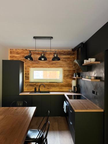 a kitchen with green cabinets and a wooden counter top at Black House in Sława