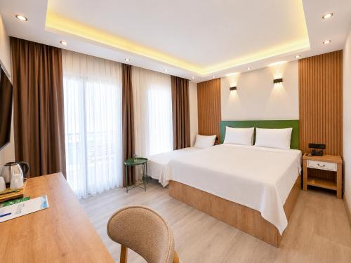 a hotel room with a large bed and a table at Ovva Inn Yeşilovacık Hotel in Dibekli