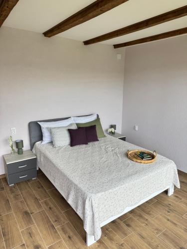 a bedroom with a large bed with a wooden floor at Apartman Domaja in Viča