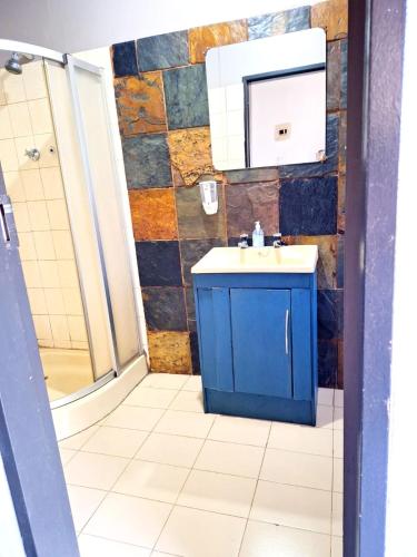 a bathroom with a blue sink and a shower at Old Mill B&B in Magaliesburg