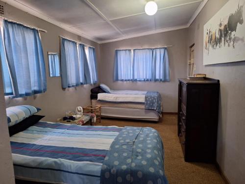 a bedroom with two beds and a dresser in it at Old Mill B&B in Magaliesburg