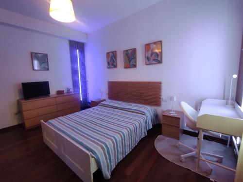 a bedroom with a bed and a sink and a television at Margot's House Rho in Rho