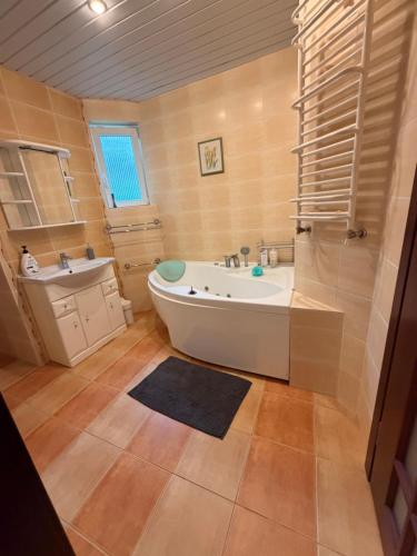 a bathroom with a tub and a sink at Villa Apartments in Palanga