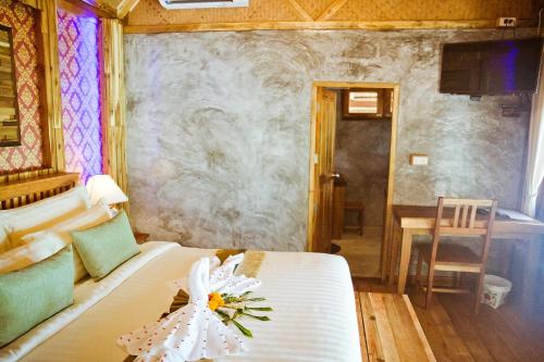 a bedroom with a bed with a flower on it at Phi Phi Phu Chalet Resort in Phi Phi Don
