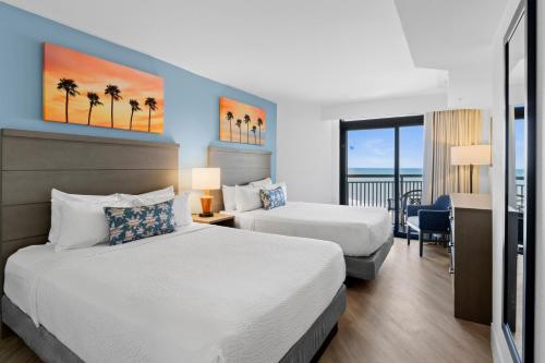 a hotel room with two beds and a desk at Ocean Reef Resort in Myrtle Beach