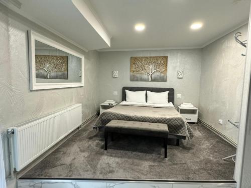 a bedroom with a bed and two paintings on the wall at Міні-готель RANDEVU in Zhytomyr