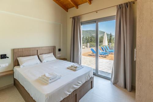 a bedroom with a bed with a view of a patio at Tsoutsis Villas in Marantochori