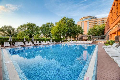 ein Schwimmbad mit Liegestühlen neben einem Gebäude in der Unterkunft Gladiola 3-star in Goldstrand
