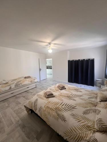 a bedroom with two beds and a ceiling fan at Eymet Holiday Rentals in Eymet