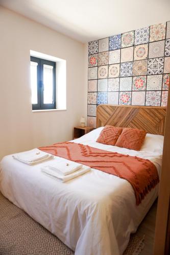 a bedroom with a large bed with white sheets at VIELA Guest House Premium in Barcelos