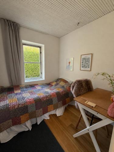 a bedroom with a bed and a window at Krageholmshytten in Karrebæksminde
