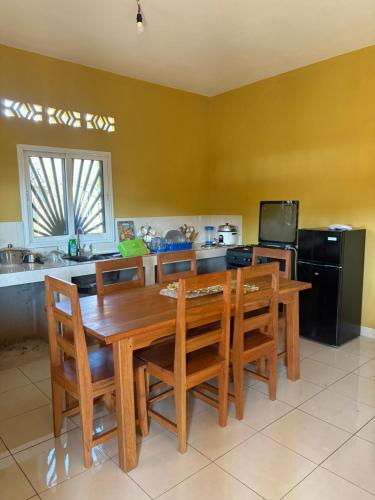 a kitchen with a wooden dining room table and chairs at Villa Donia Nosy be in Nosy Be