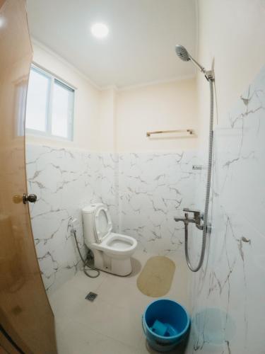 a white bathroom with a toilet and a shower at Balud White Beach Resort in Moalboal