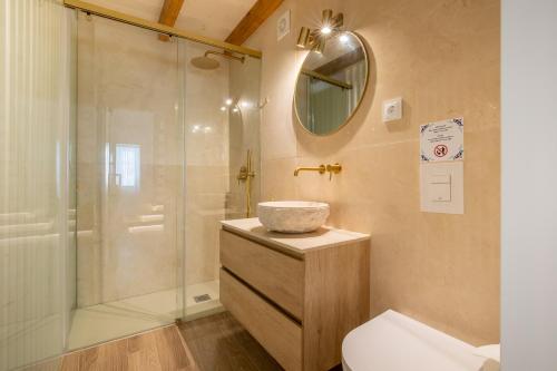 a bathroom with a shower and a toilet and a sink at Casinha do Beco in Lagos