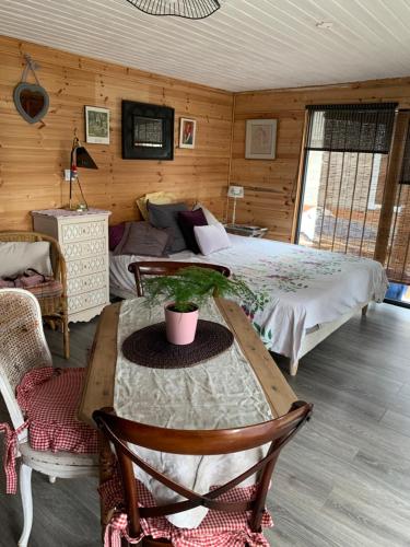 a bedroom with a bed and a table with a plant on it at Châlet de charme in Taillet