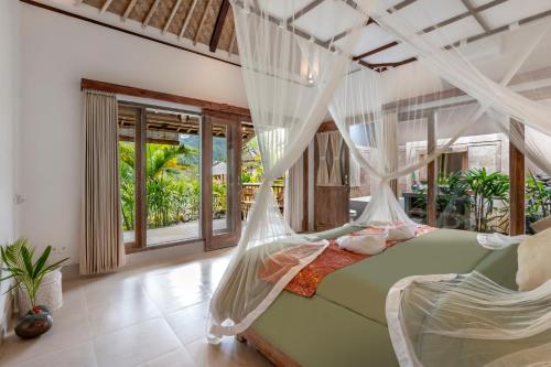 a bedroom with a green bed with mosquito nets at ArtVilla Sidemen River in Sidemen