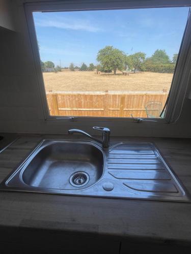 a sink in front of a window with a view of a field at Gunthorpe Mobile Home in East Bridgford