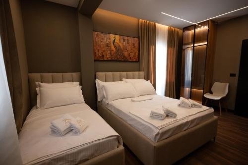 two beds in a hotel room with towels on them at 2S Vila Boutique Pogradec in Pogradec