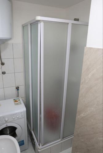 eine Duschkabine im Badezimmer neben einer Waschmaschine in der Unterkunft Square Studio Brcko in Brčko