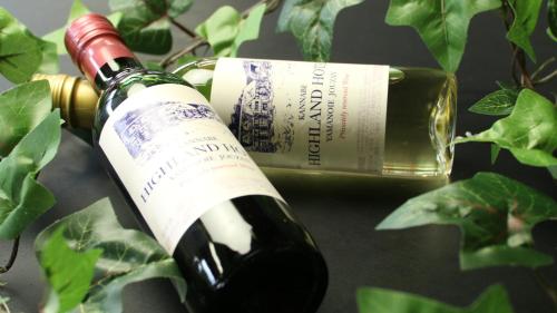 a bottle of wine sitting next to a wine glass at Kannabe Highland Hotel in Toyooka