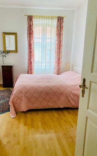 a bedroom with a pink bed and a window at Dinkelsbühl-Ferienappartement in Mönchsroth