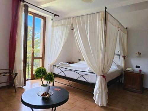 a bedroom with a canopy bed and a table at Hotel Residence Sant'Uberto in Roccastrada