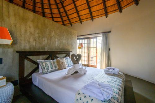 a bedroom with a bed with a stuffed animal on it at Mbizi Bush Lodge in Grietjie Game Reserve