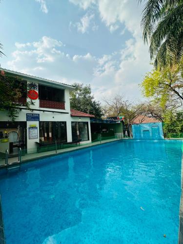 a large blue swimming pool in front of a building at The Whispering Palms Resort in Bhopal