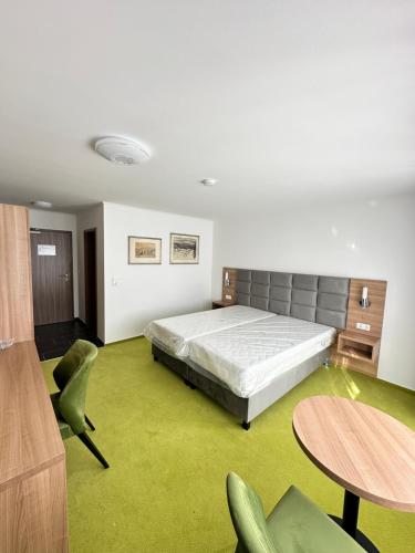 a bedroom with a bed and a table and chairs at EDELFUCHS Rote-Lache in Forbach