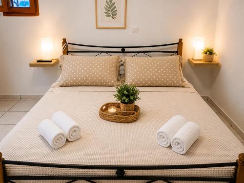 a bed with towels and a basket with a plant on it at Georgoulis Home in Ambelókipoi