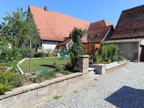 a backyard with a stone retaining wall and a garden at Ferienhaus Mitteldachstetten, ruhige Lage, kostenlos parken, WLAN free in Oberdachstetten