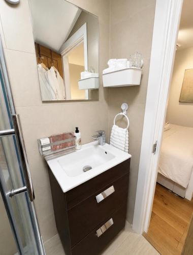 a bathroom with a sink and a mirror at The Old Pub Wiltshire A Unique Luxury Cellar Retreat with Private Sauna Gym and Movie Room in Patney