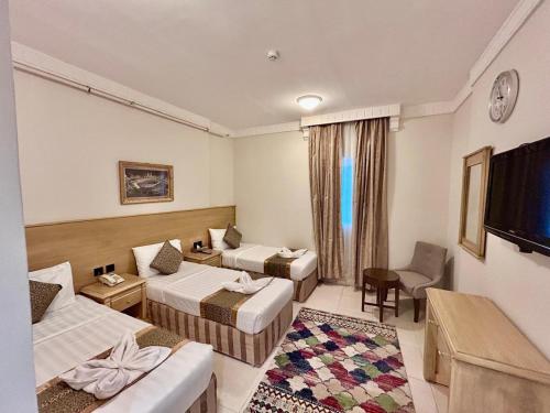 a hotel room with two beds and a television at فندق درة طيبة 3 in Az Zahrāʼ