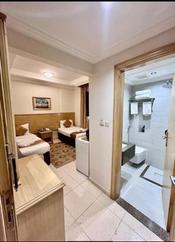 a hotel room with a bedroom and a bathroom at فندق درة طيبة 3 in Az Zahrāʼ