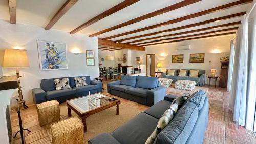 a living room with blue couches and a table at Sol - Private Pool - 14 Guests - Vilamoura in Vilamoura