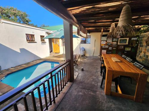 a patio with a table and a swimming pool at OppiePlaas Country Estate in Haga-Haga