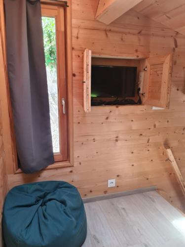 a log cabin with a large window and a round bed in the room at Tiny Isle in L'Isle-sur-la-Sorgue